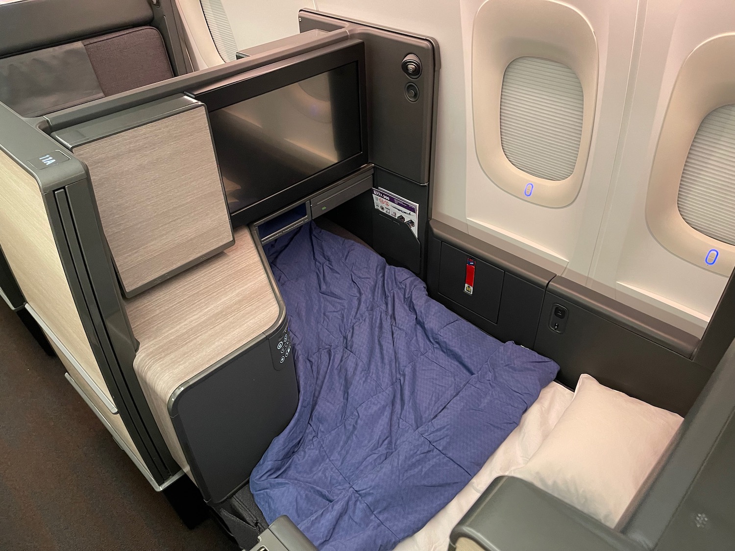 a bed with a blanket in the back of a plane