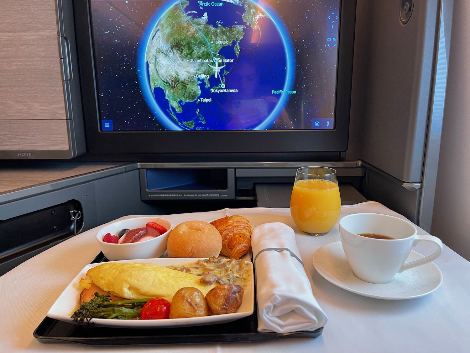 a tray of food and a cup of coffee on a table with a television