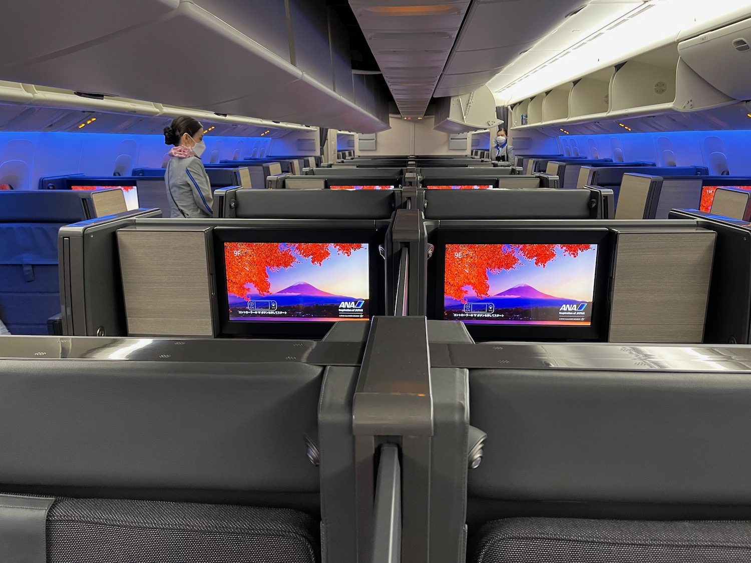 a woman standing in an airplane with several monitors