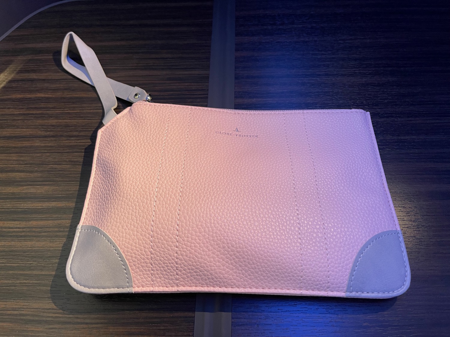 a pink and grey purse on a table