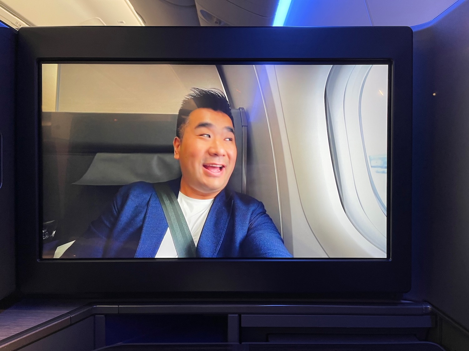 a man in a blue suit sitting in a plane