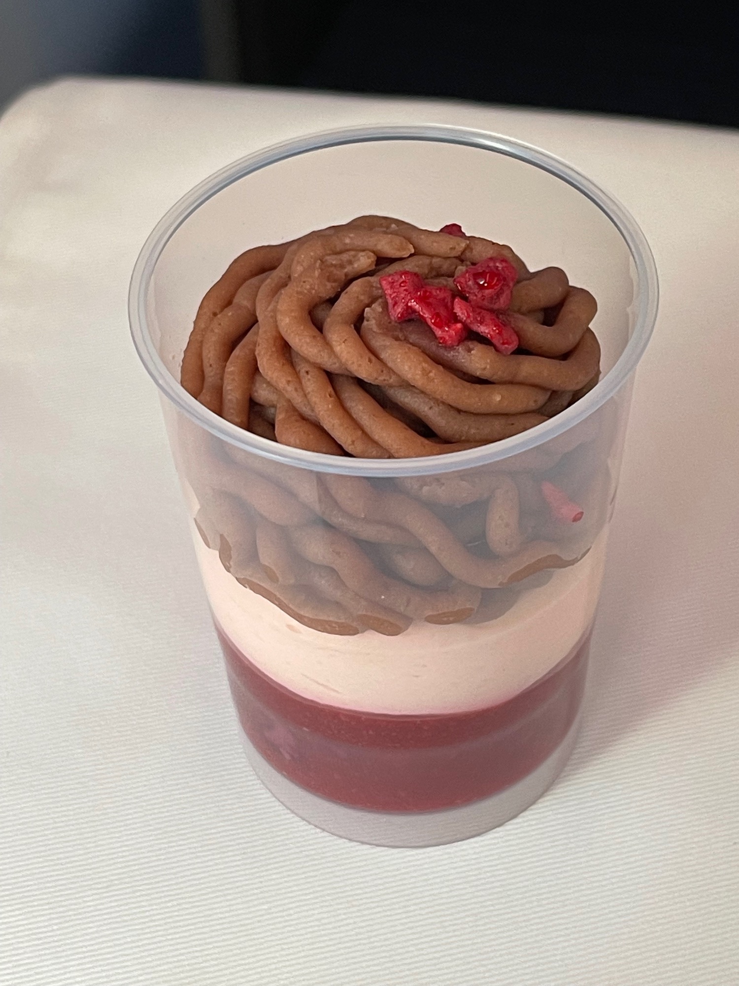 a cup of dessert with a brown and white layer of food