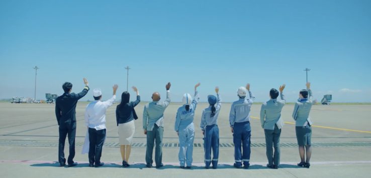 a group of people standing in a line with their hands up