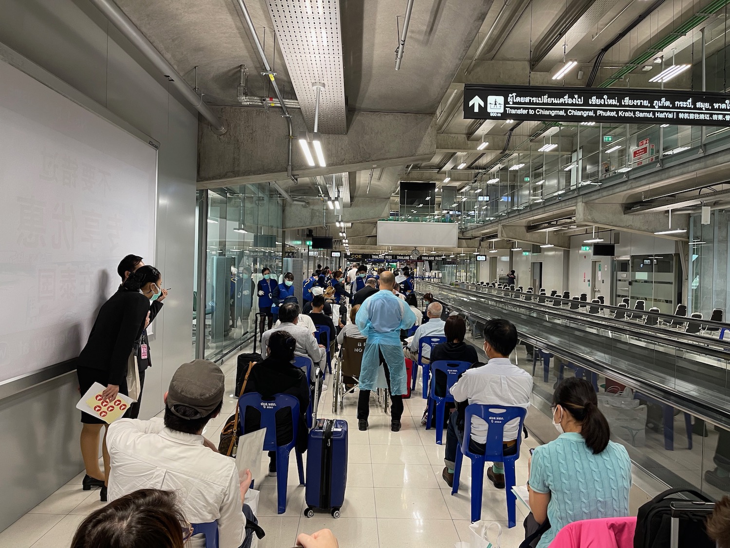 a group of people in a room with luggage