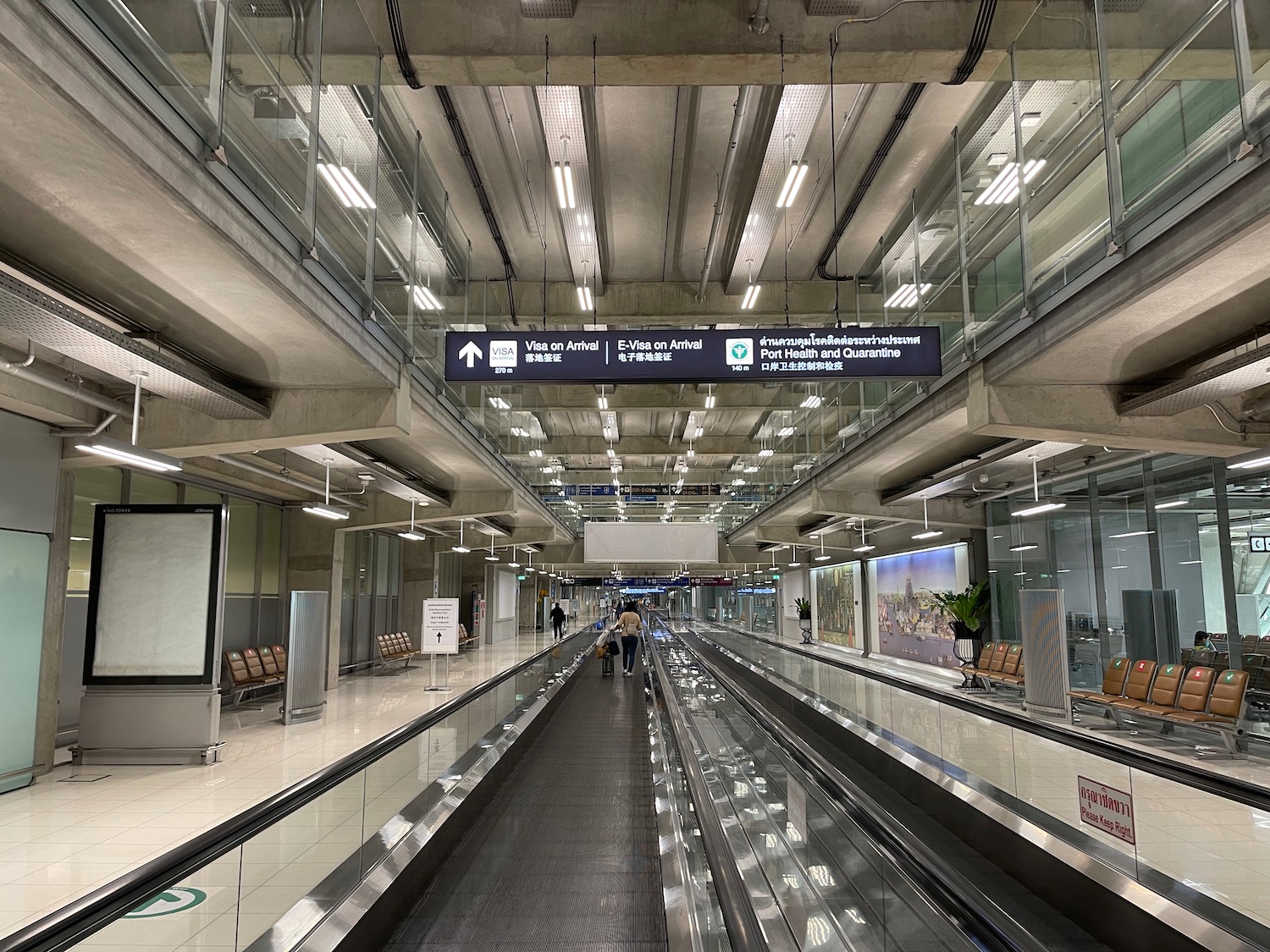 a large airport terminal with a walkway and people