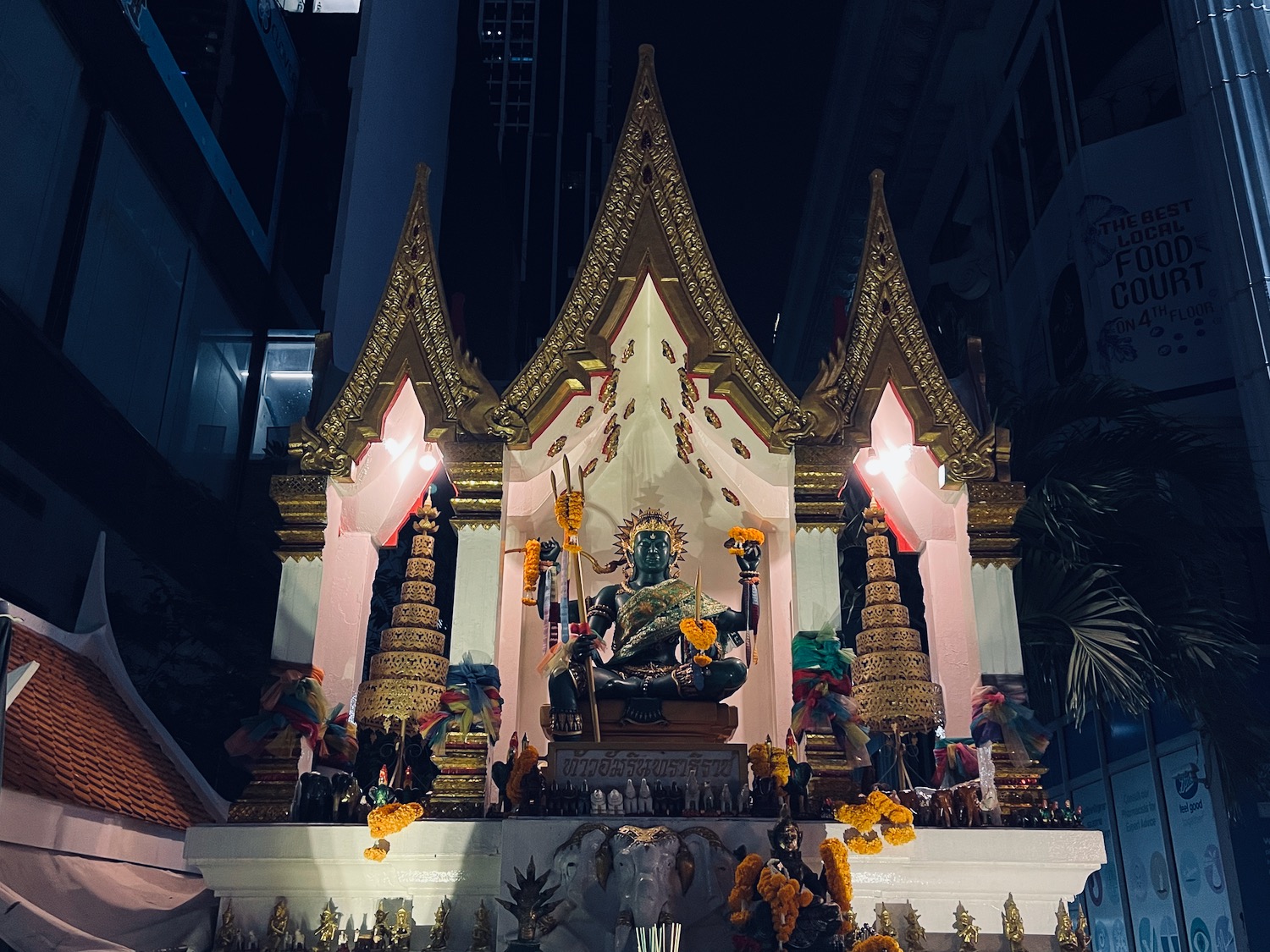 a statue of a person sitting on a small shrine