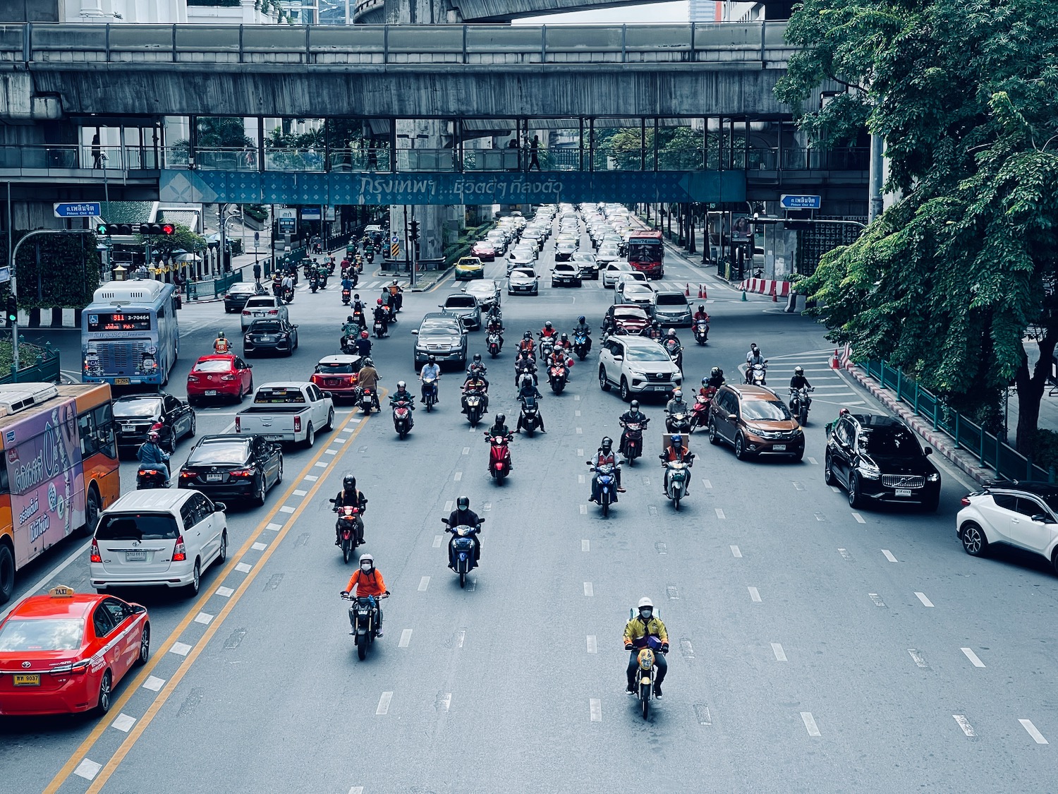 a group of people on motorcycles and cars on a street