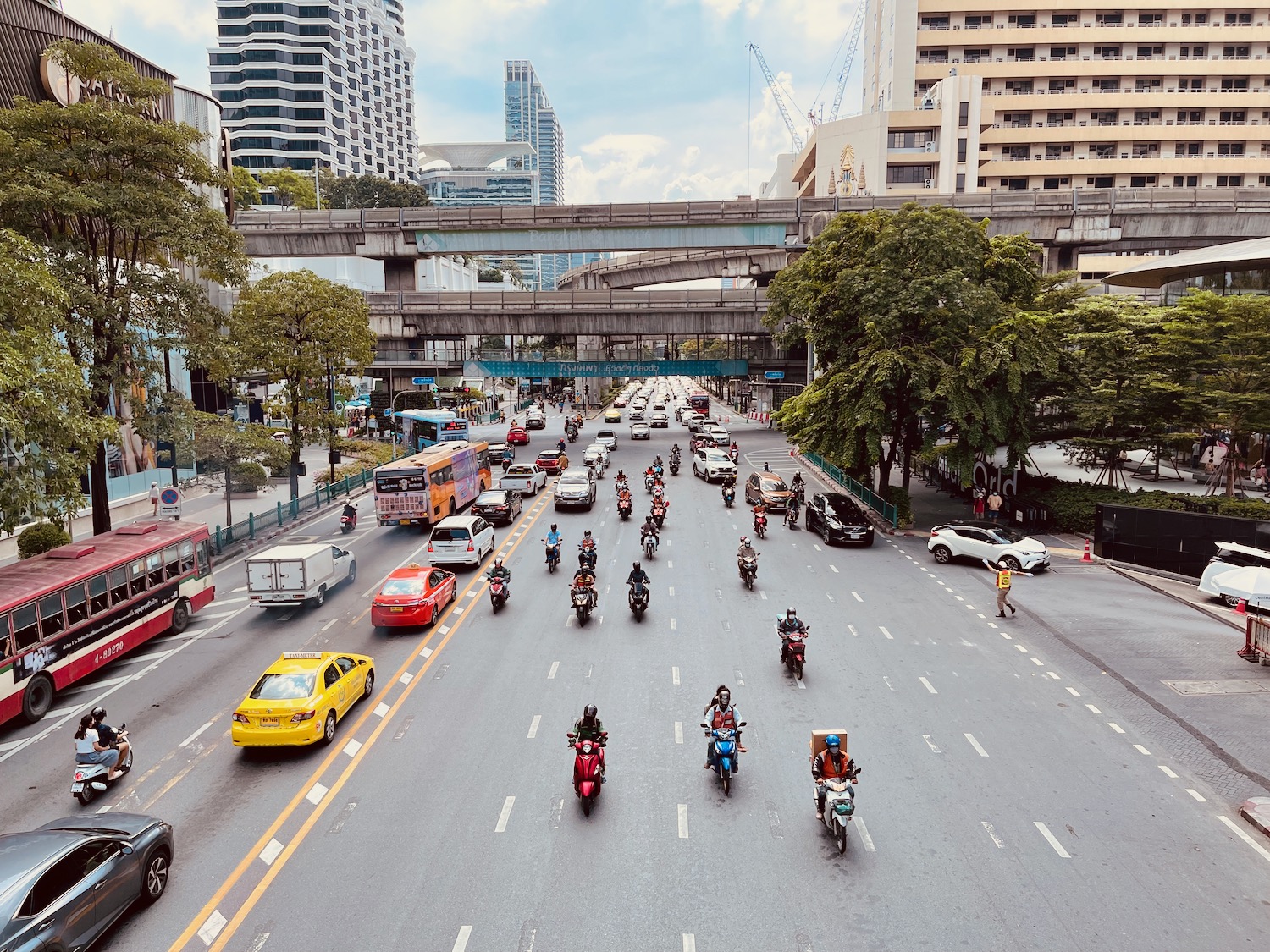 a group of people on motorcycles and cars on a street