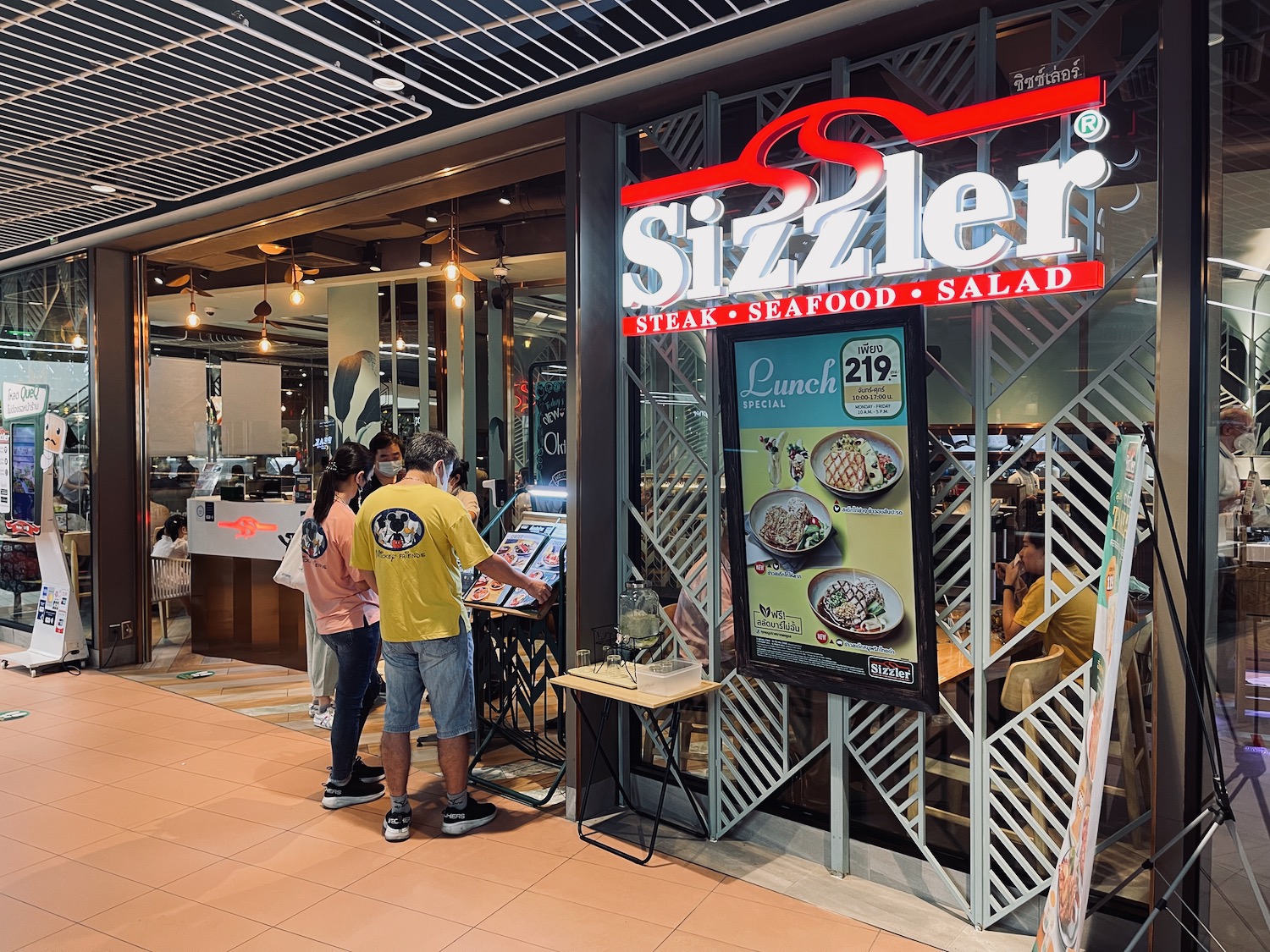 a group of people standing in front of a restaurant