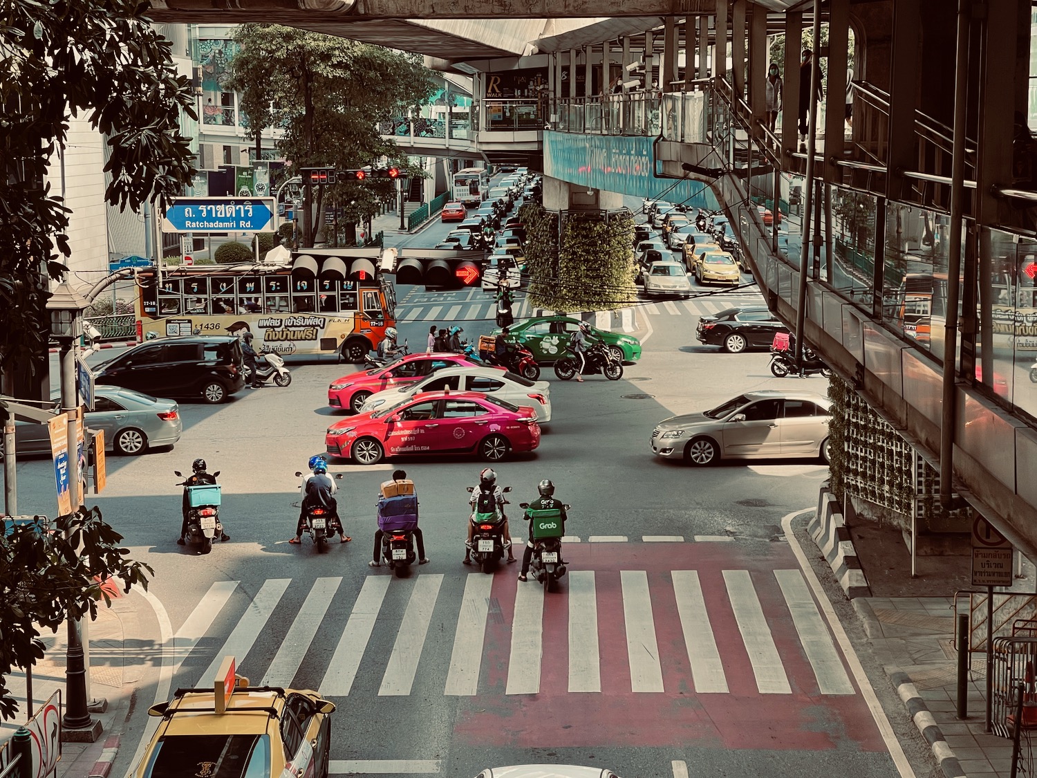 a group of people on motorcycles and cars in a busy city street