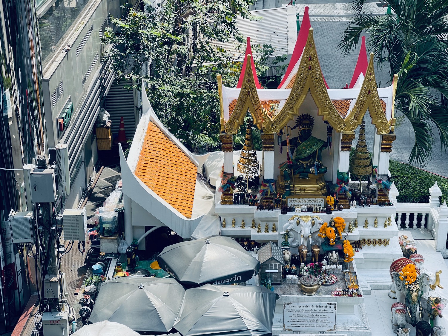 a small shrine with an elephant statue and umbrellas