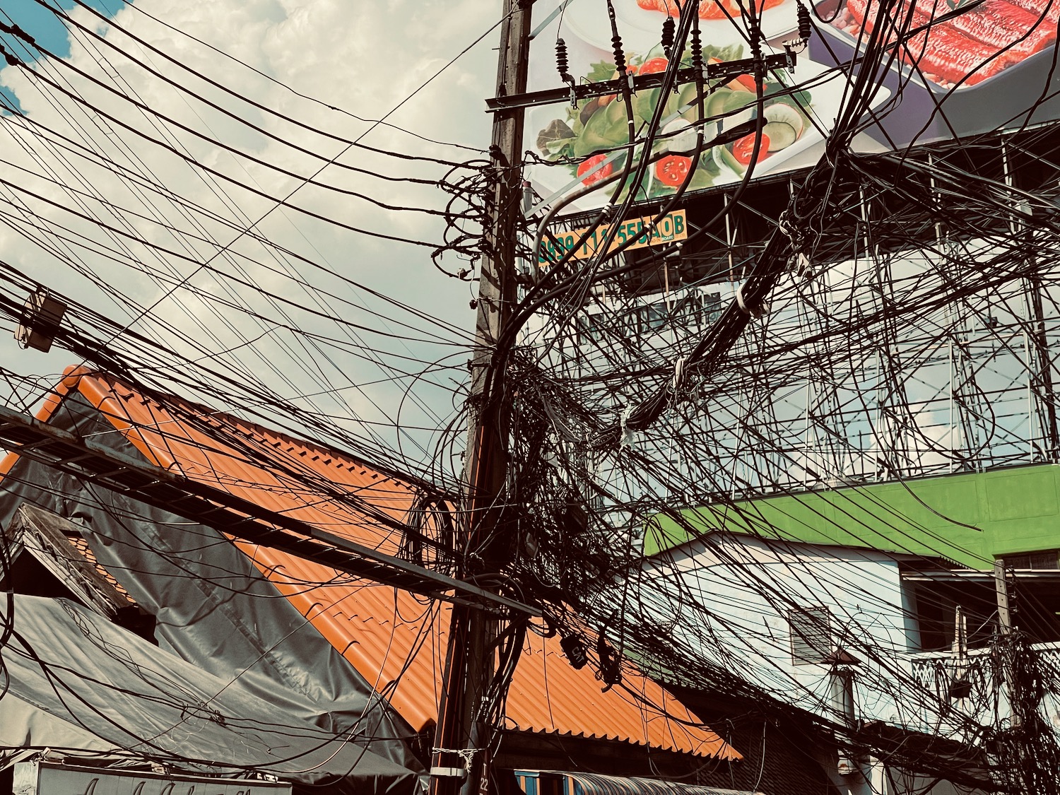 a telephone pole with wires and a sign