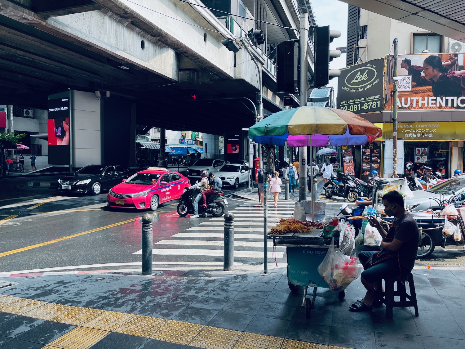 a street with a food cart and people on it
