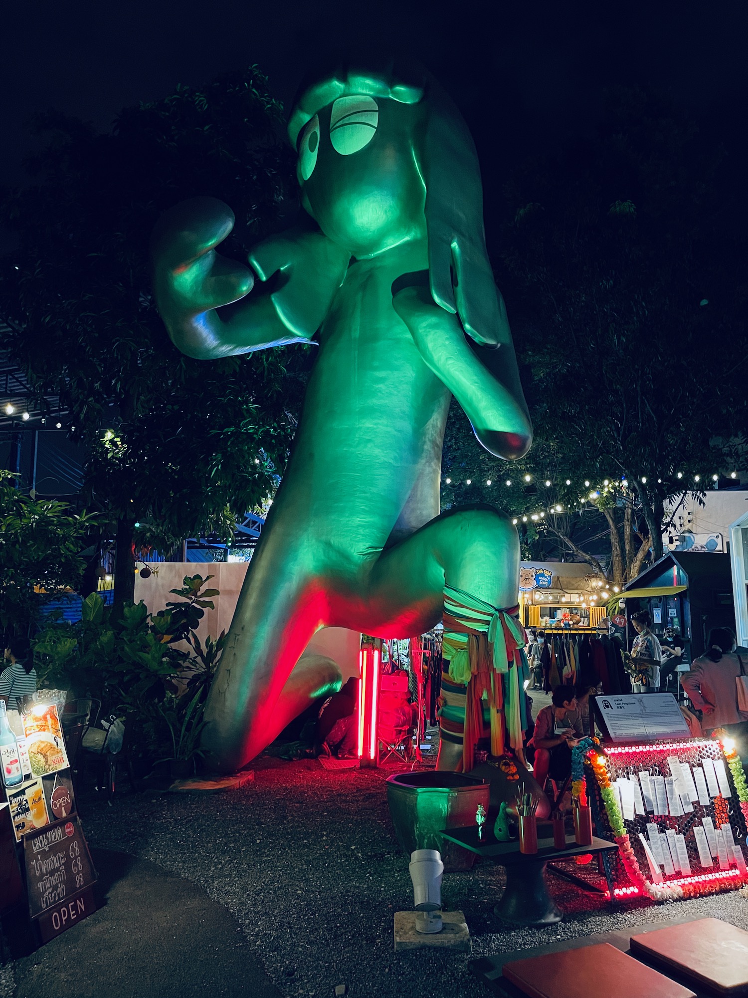 a large green statue of a person with long hair