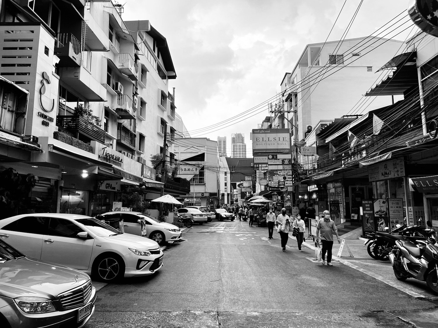 a street with cars and people walking on it