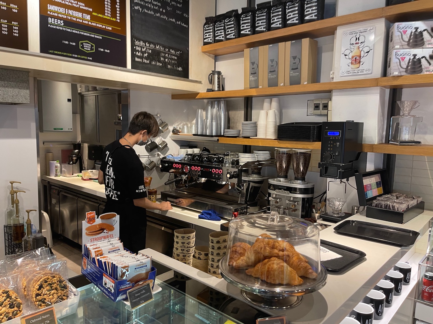 a person standing at a counter in a coffee shop