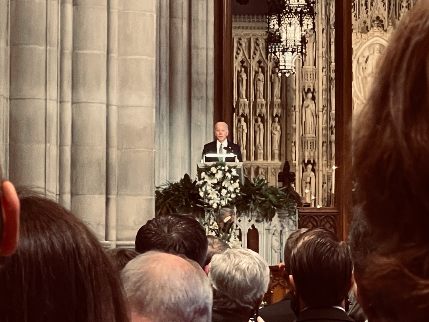 a man standing at a podium with a crowd of people