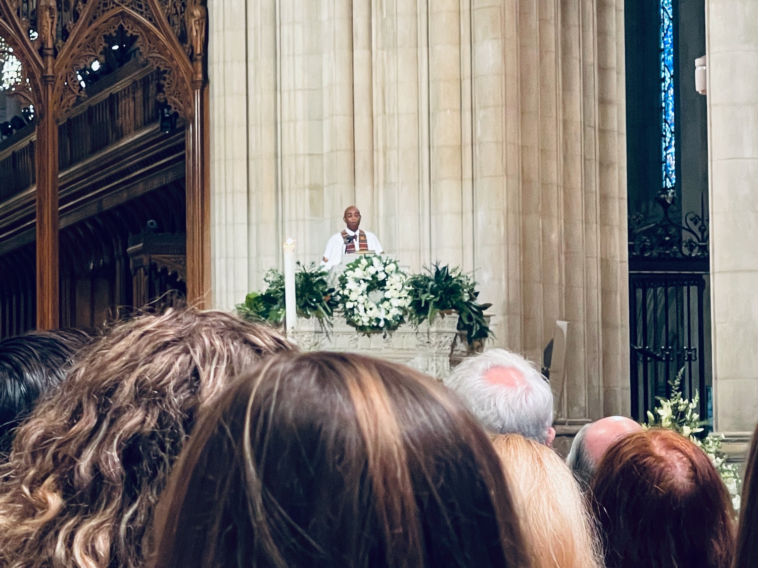 a man standing on a podium with a candle and flowers