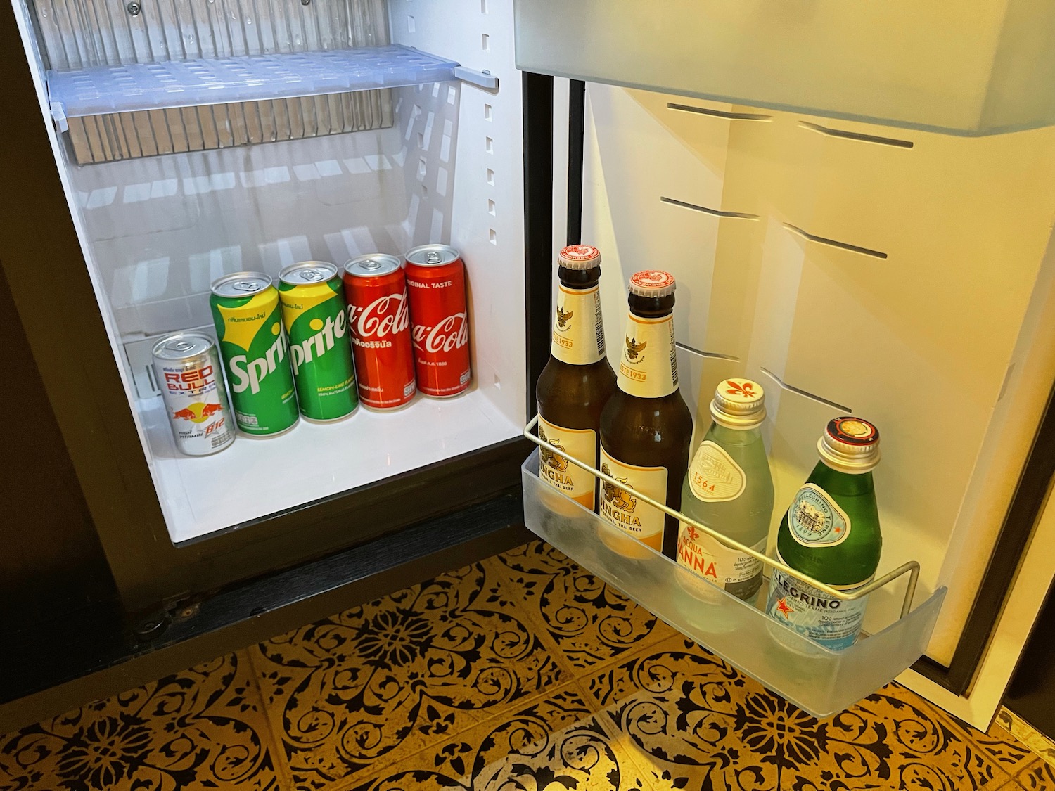 a refrigerator with bottles of soda and cans of different brands