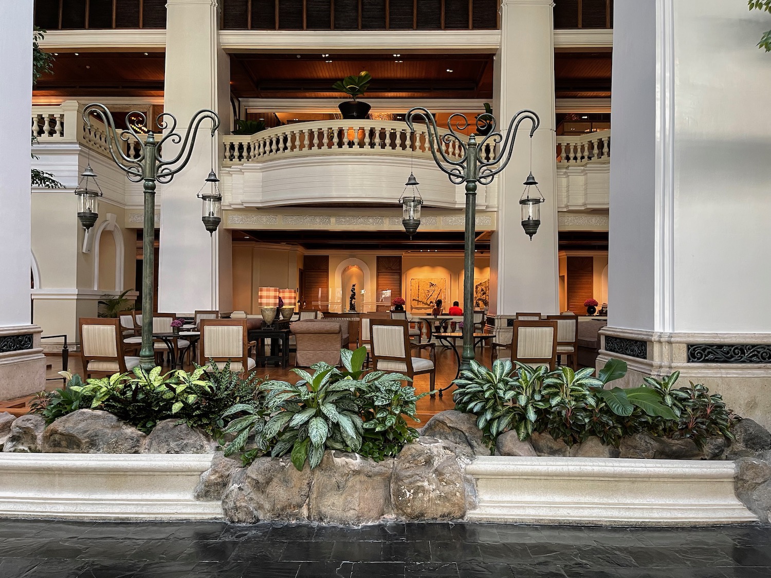 a large building with plants and a balcony