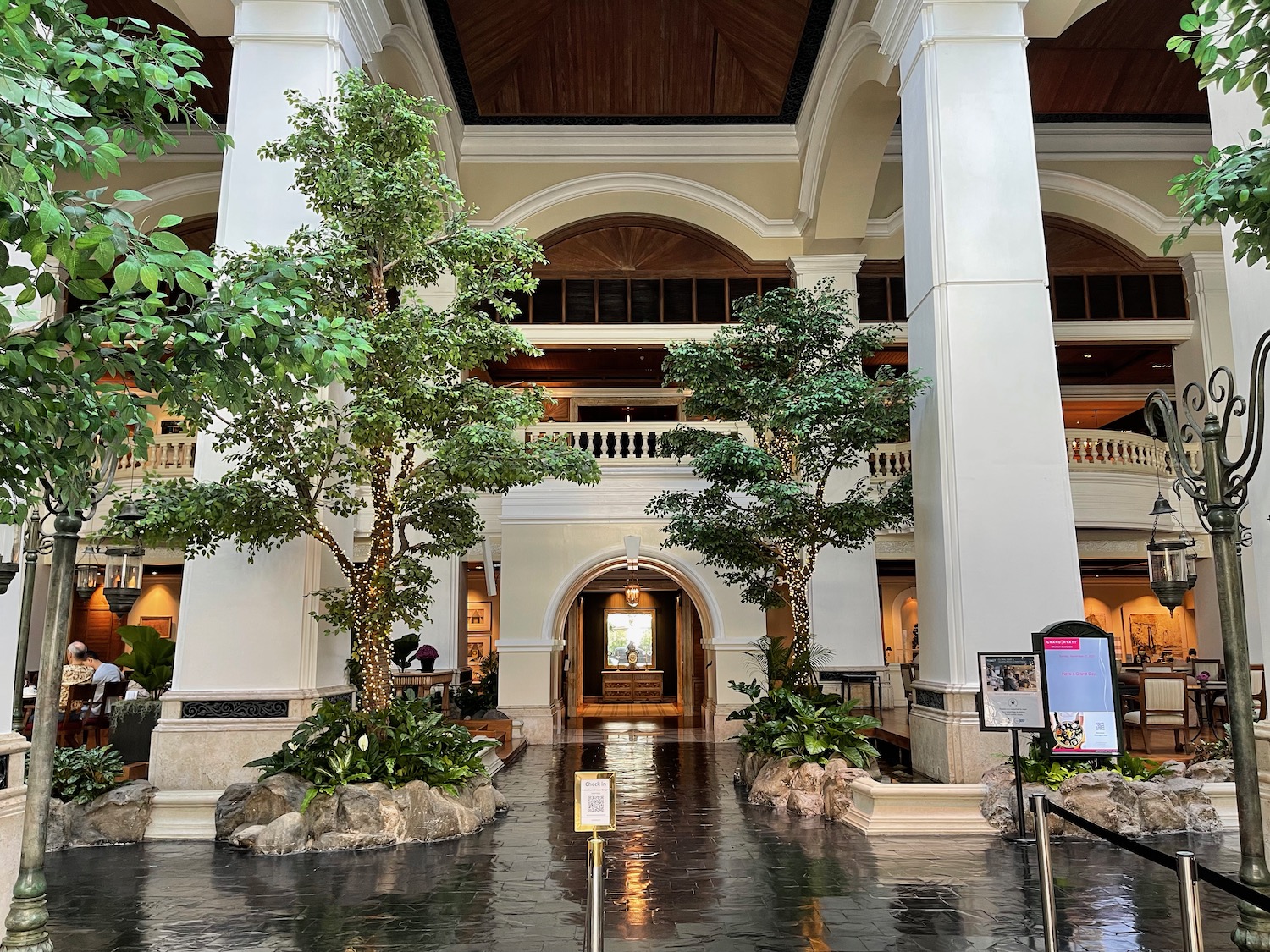 a large building with trees and a sign