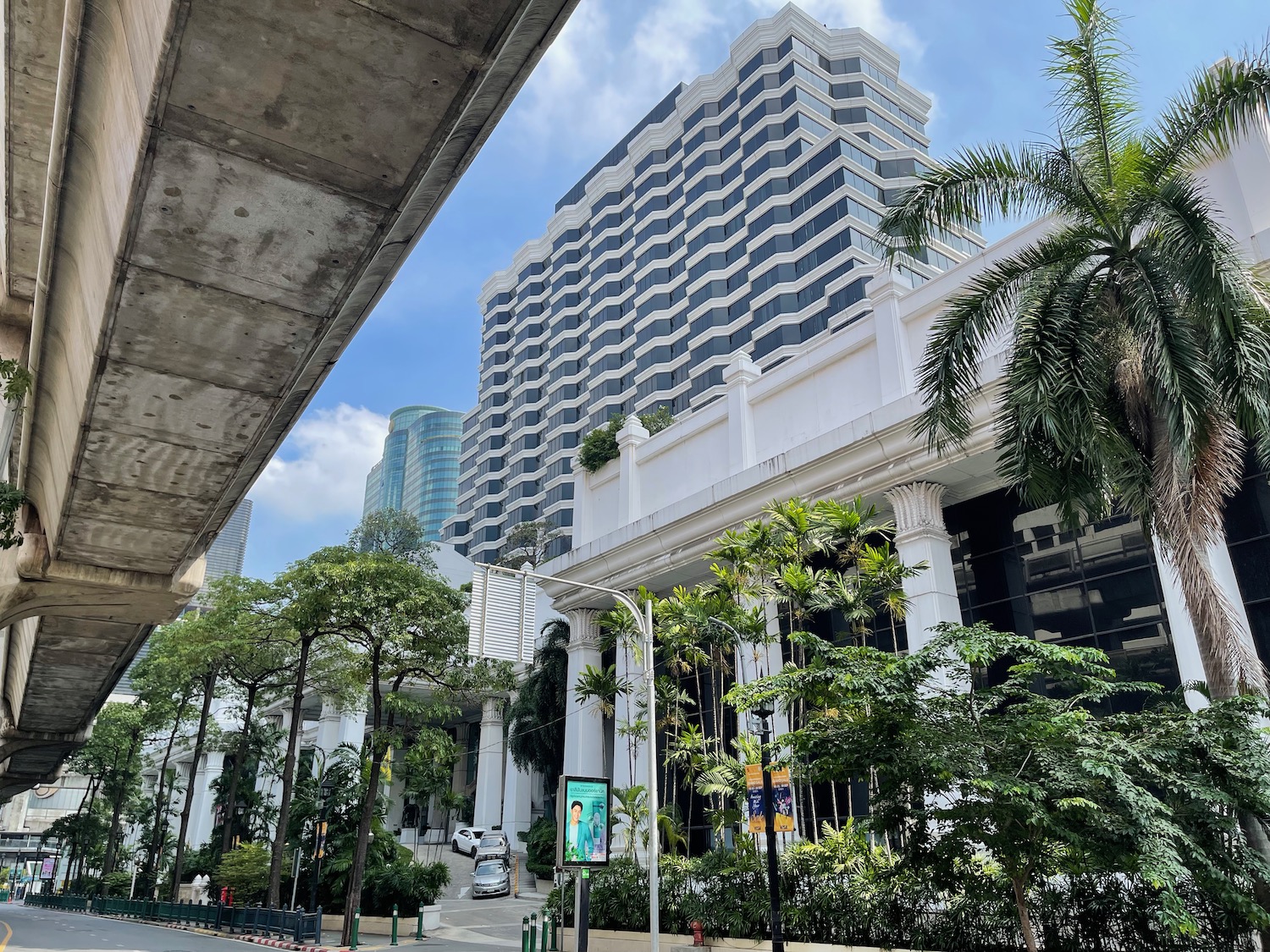 a building with trees and a street under a bridge