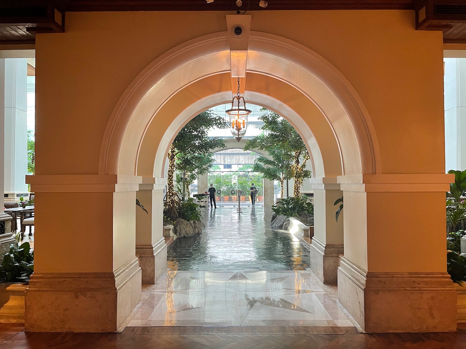 a hallway with trees and a light fixture