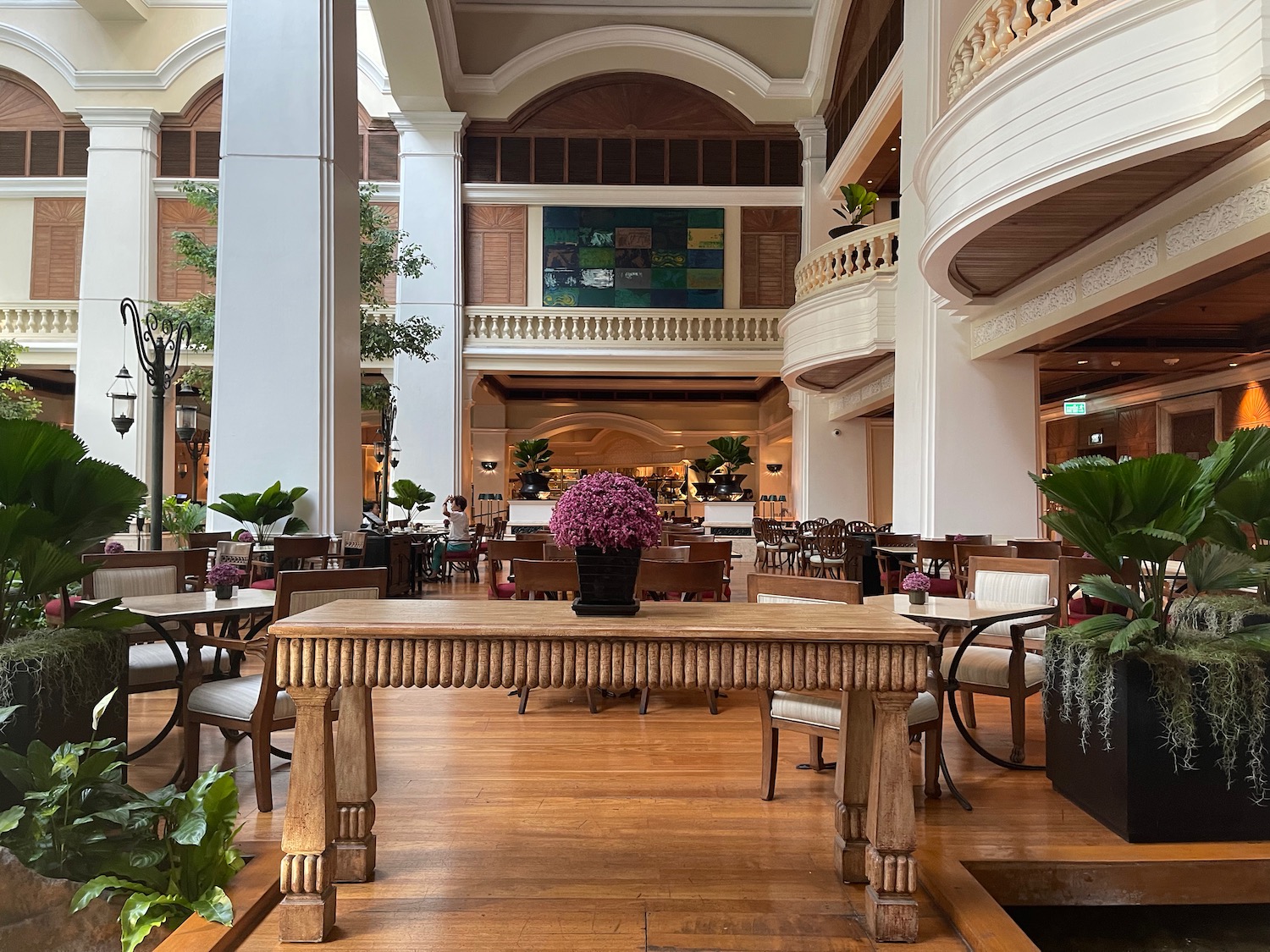 a room with tables and chairs and plants