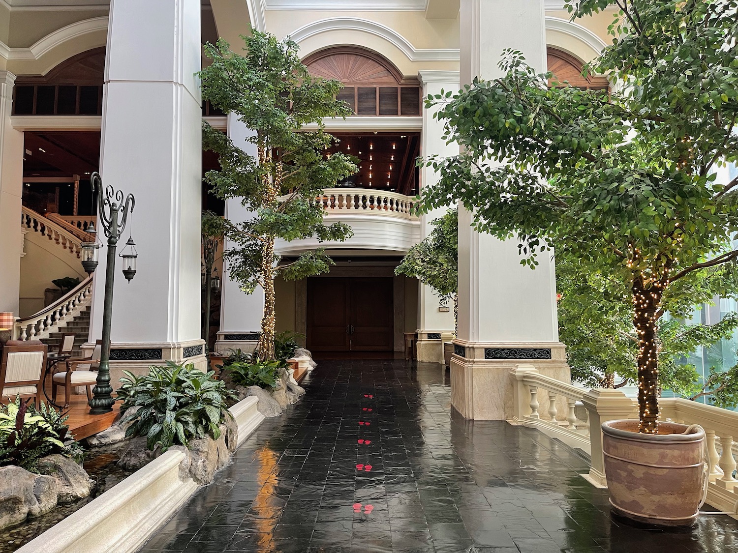 a walkway with trees and plants in front of a building