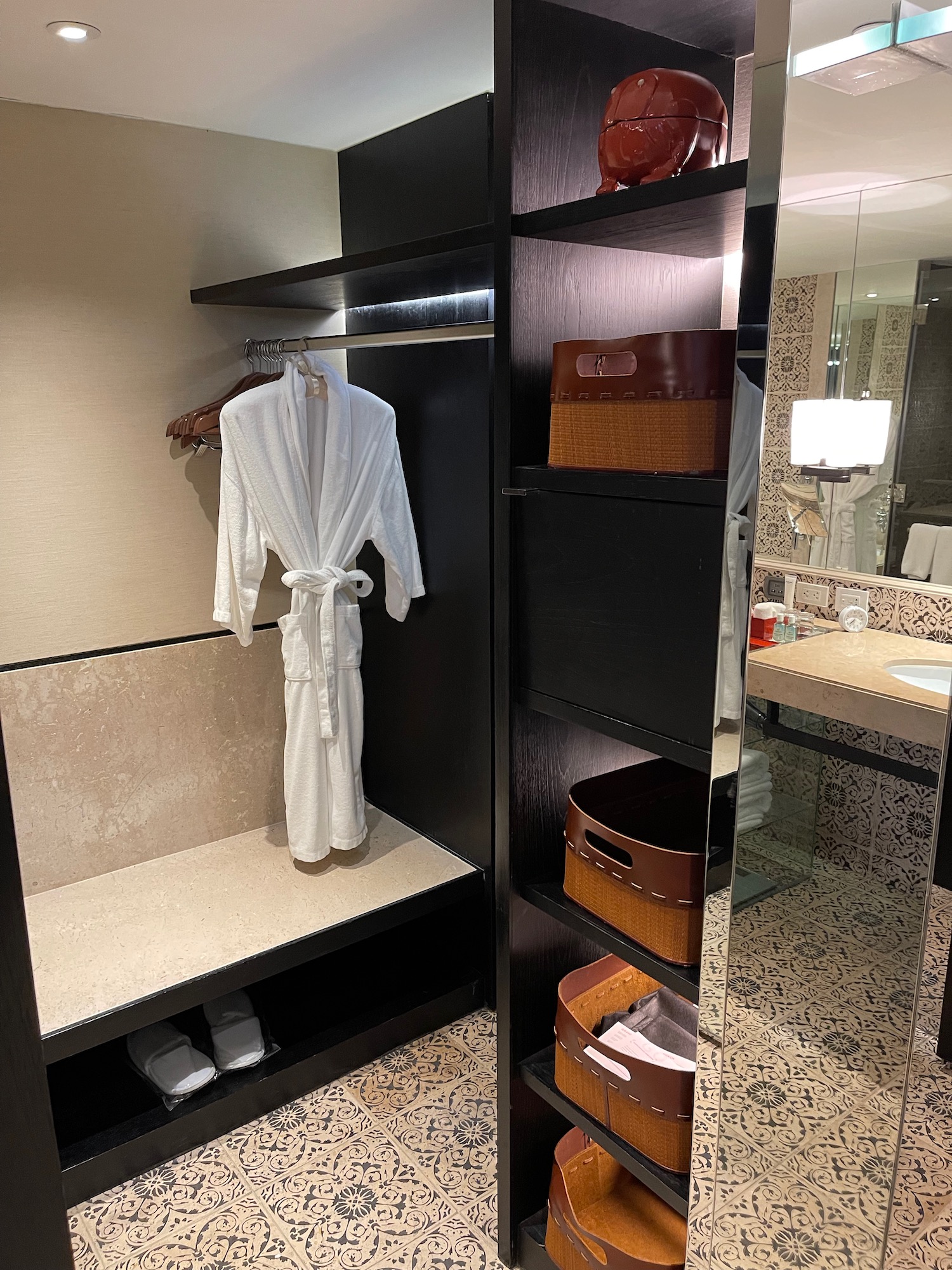 a bathroom with a white robe and shelves