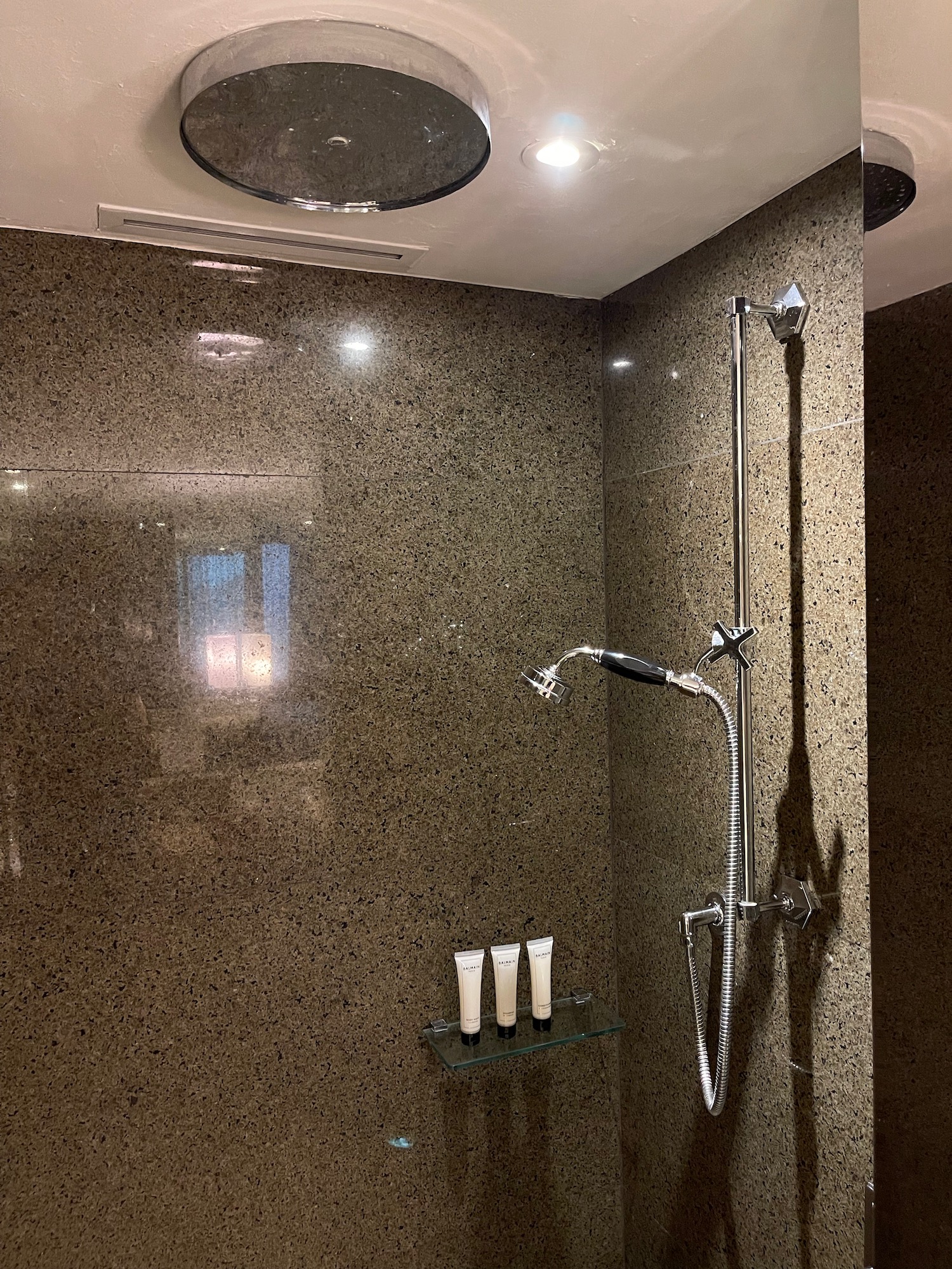 a shower with a round ceiling light