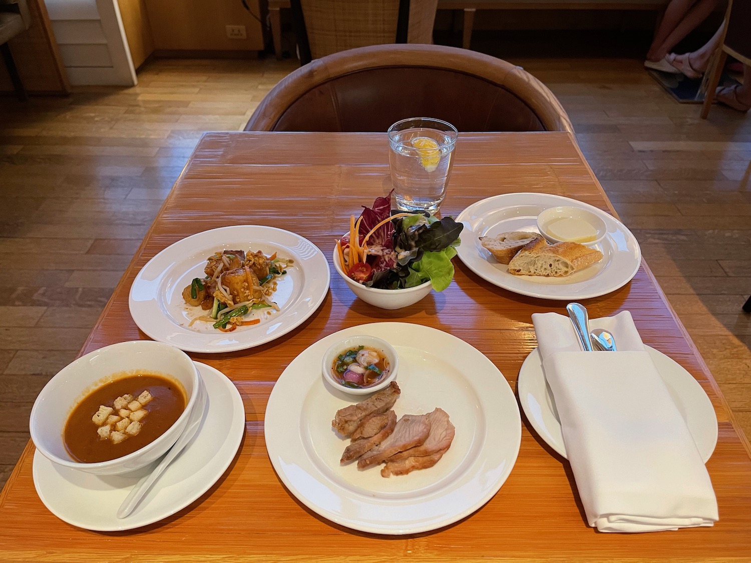 a table with plates of food and a glass of water