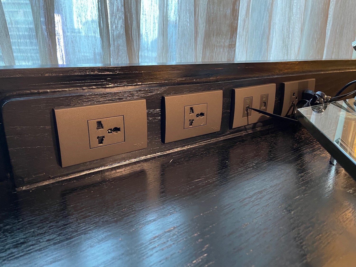a row of electrical outlets on a wood surface