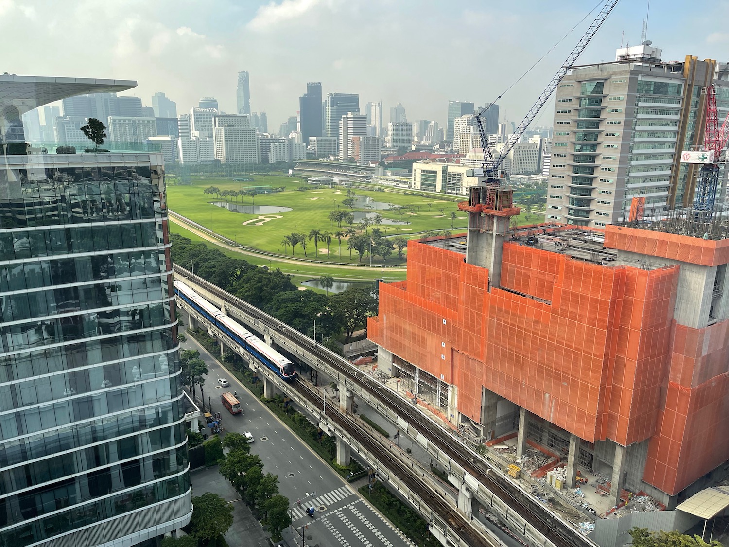 a construction site with a train and a city in the background