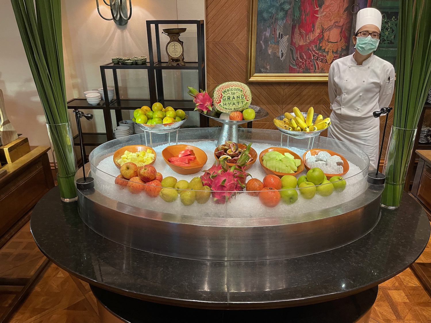 a woman standing behind a display of fruit