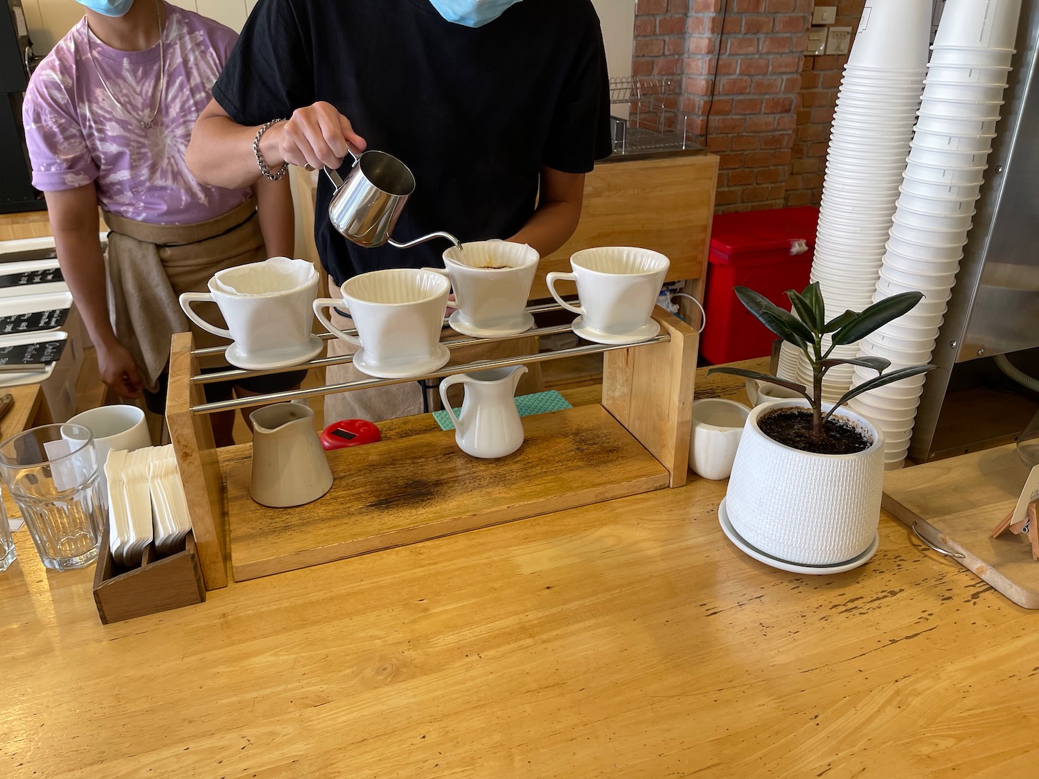a person pouring coffee into cups