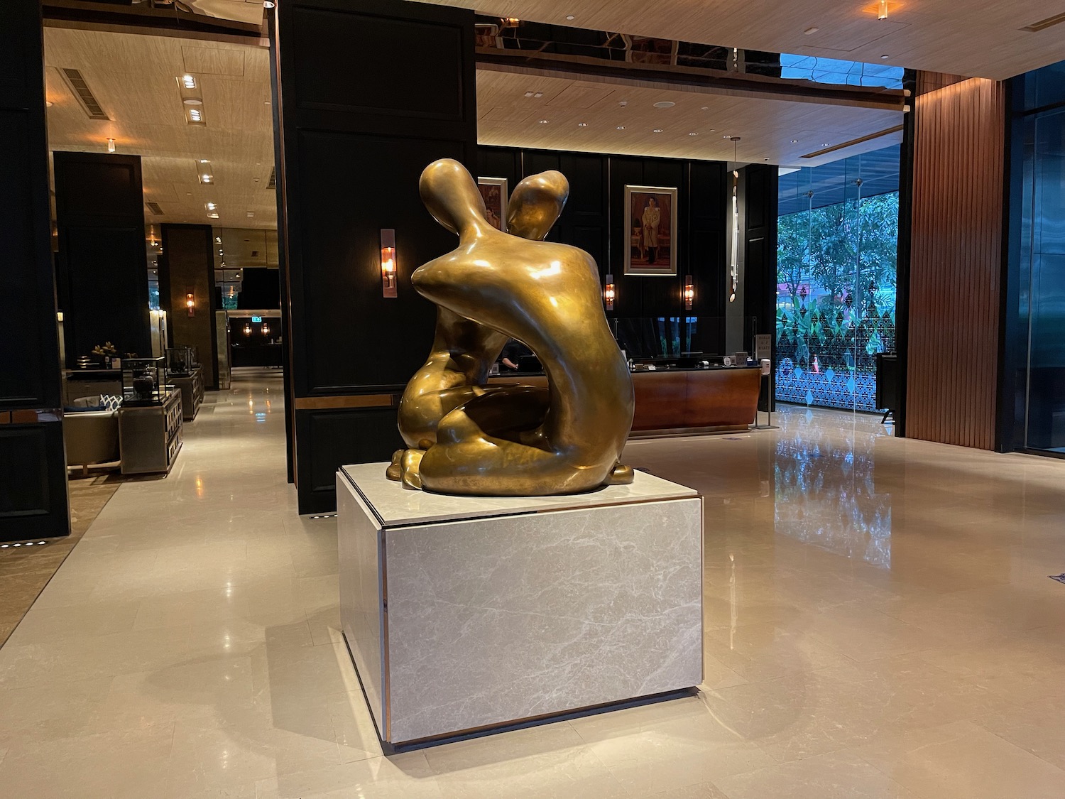 a statue of two people sitting on a pedestal in a lobby