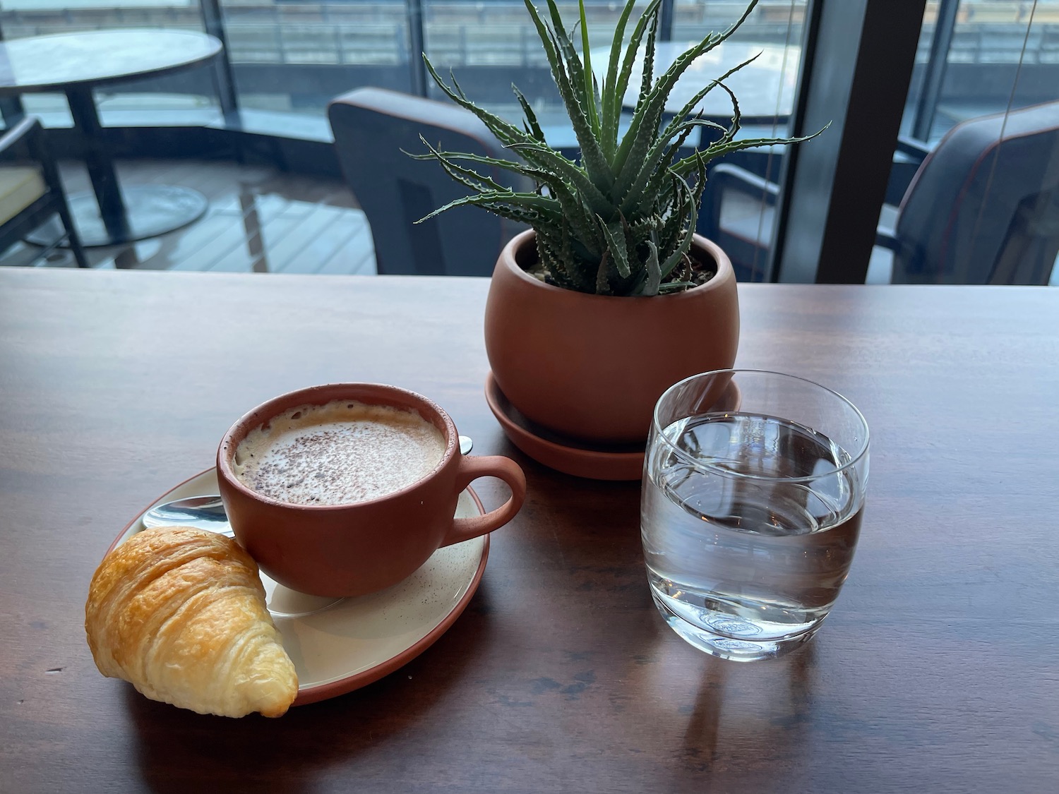 a cup of coffee and croissant on a table