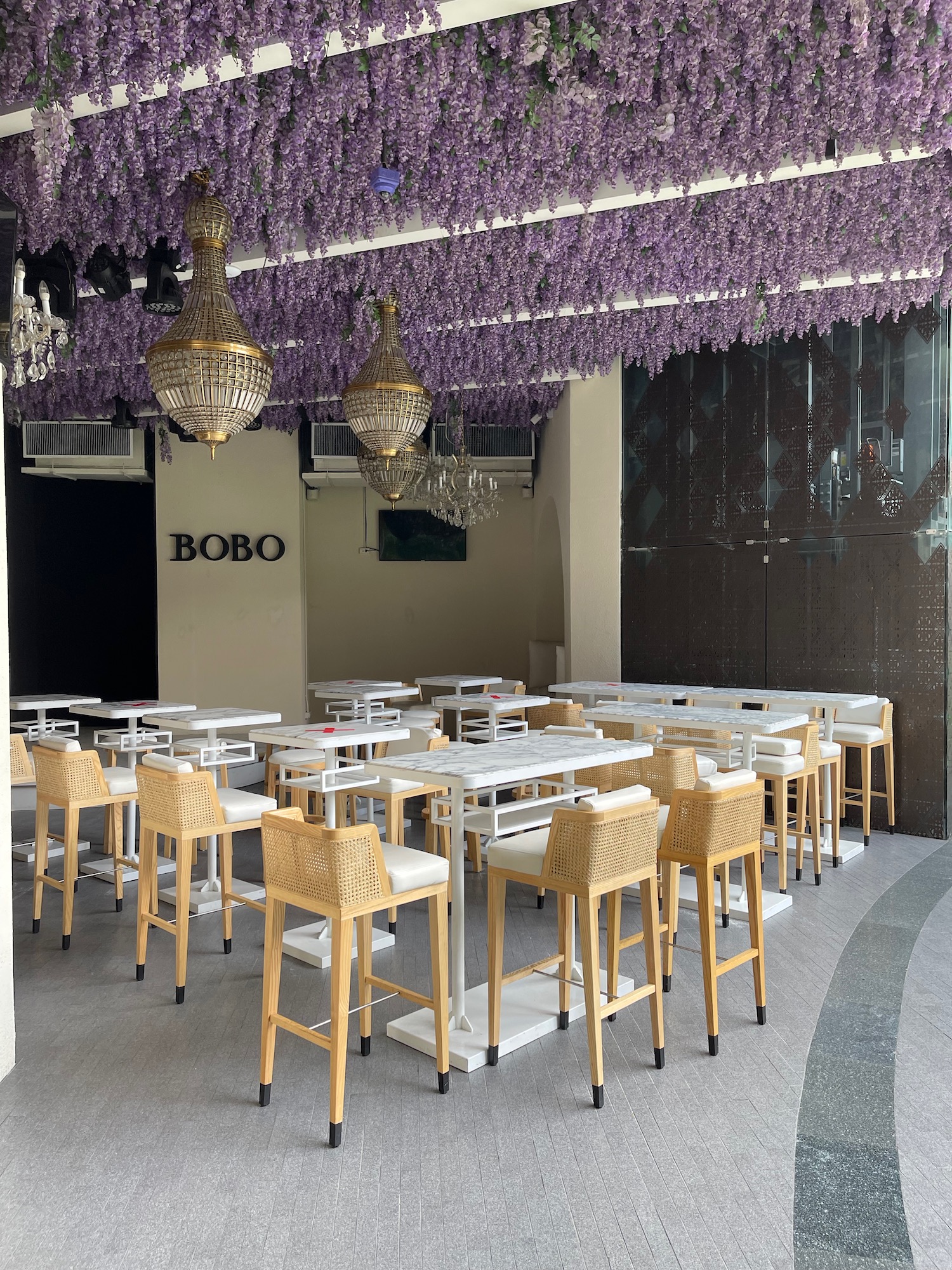 a group of tables and chairs in a room with purple flowers