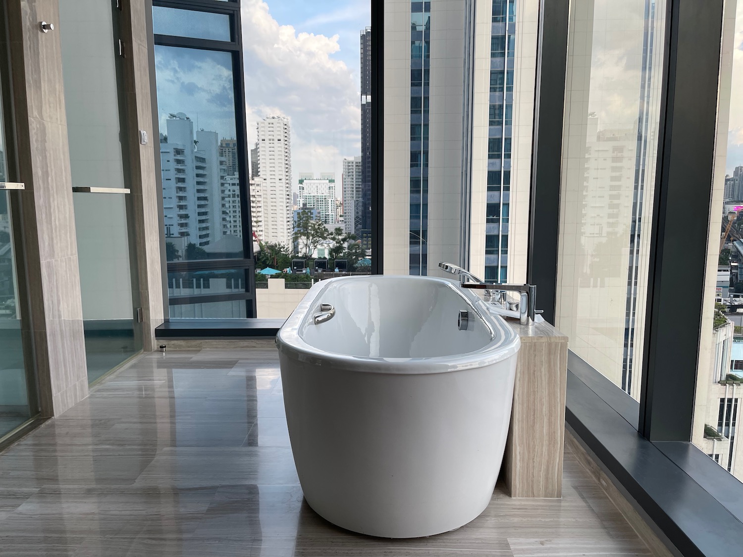 a white bathtub in a bathroom with tall windows