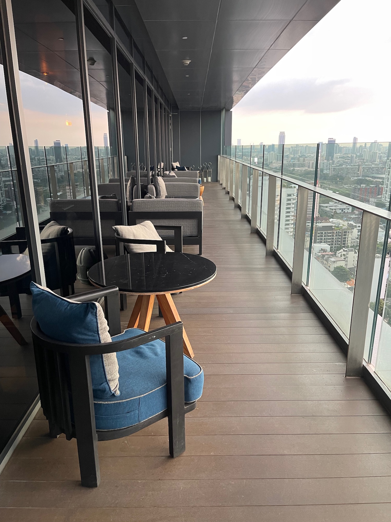 a balcony with chairs and tables and a view of a city