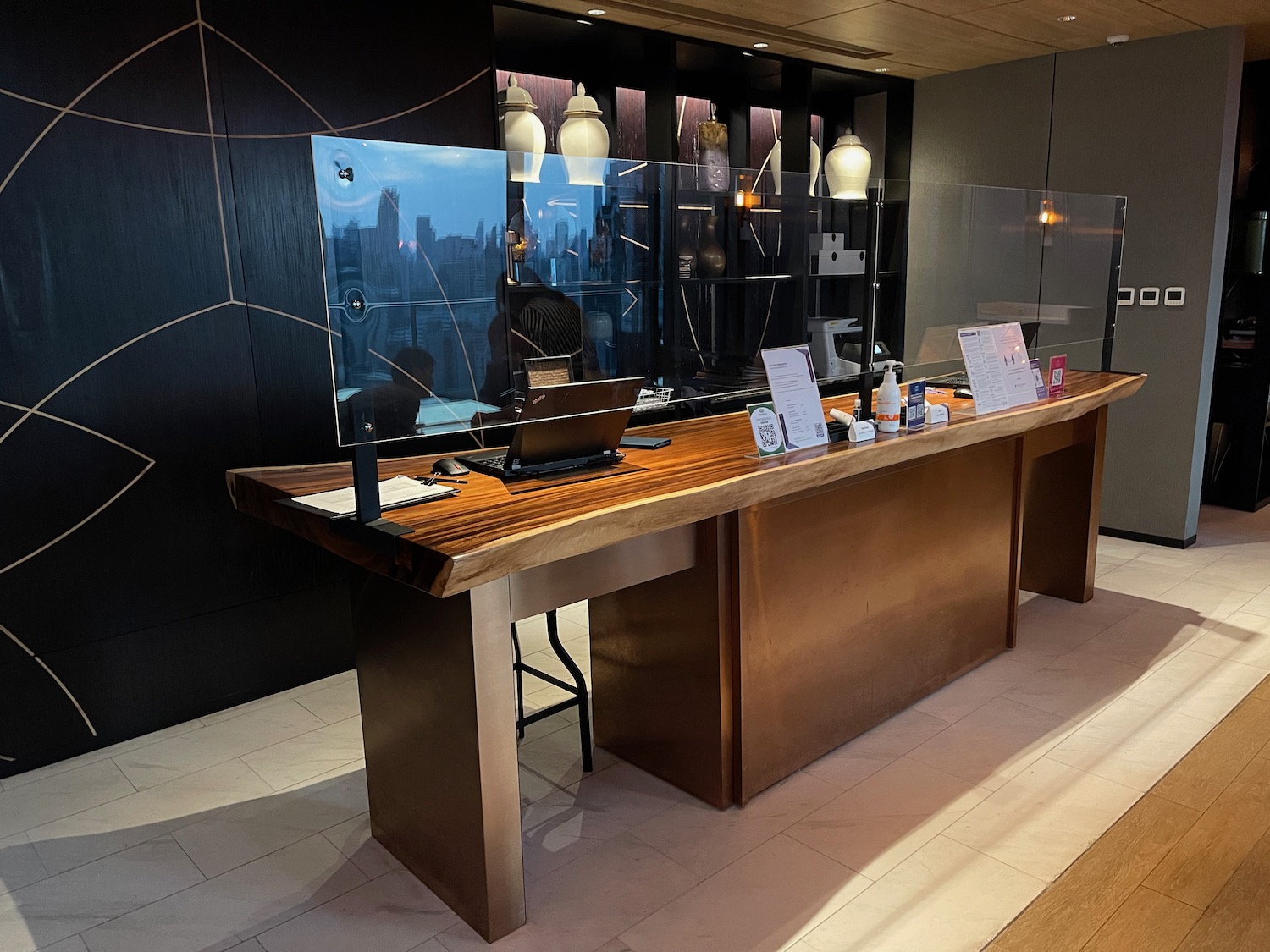 a desk with a computer and a glass wall behind it