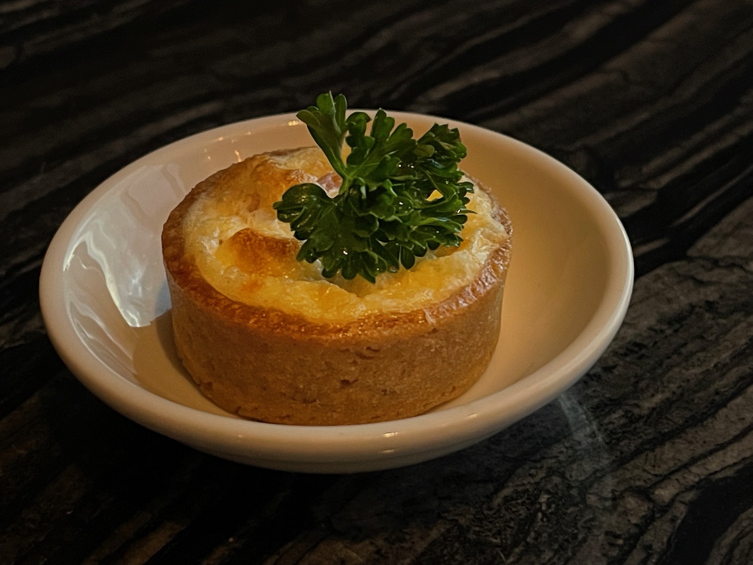 a small round pastry with a leafy green garnish on top