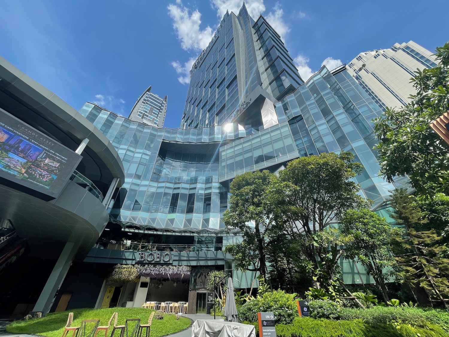 a tall building with glass walls and trees