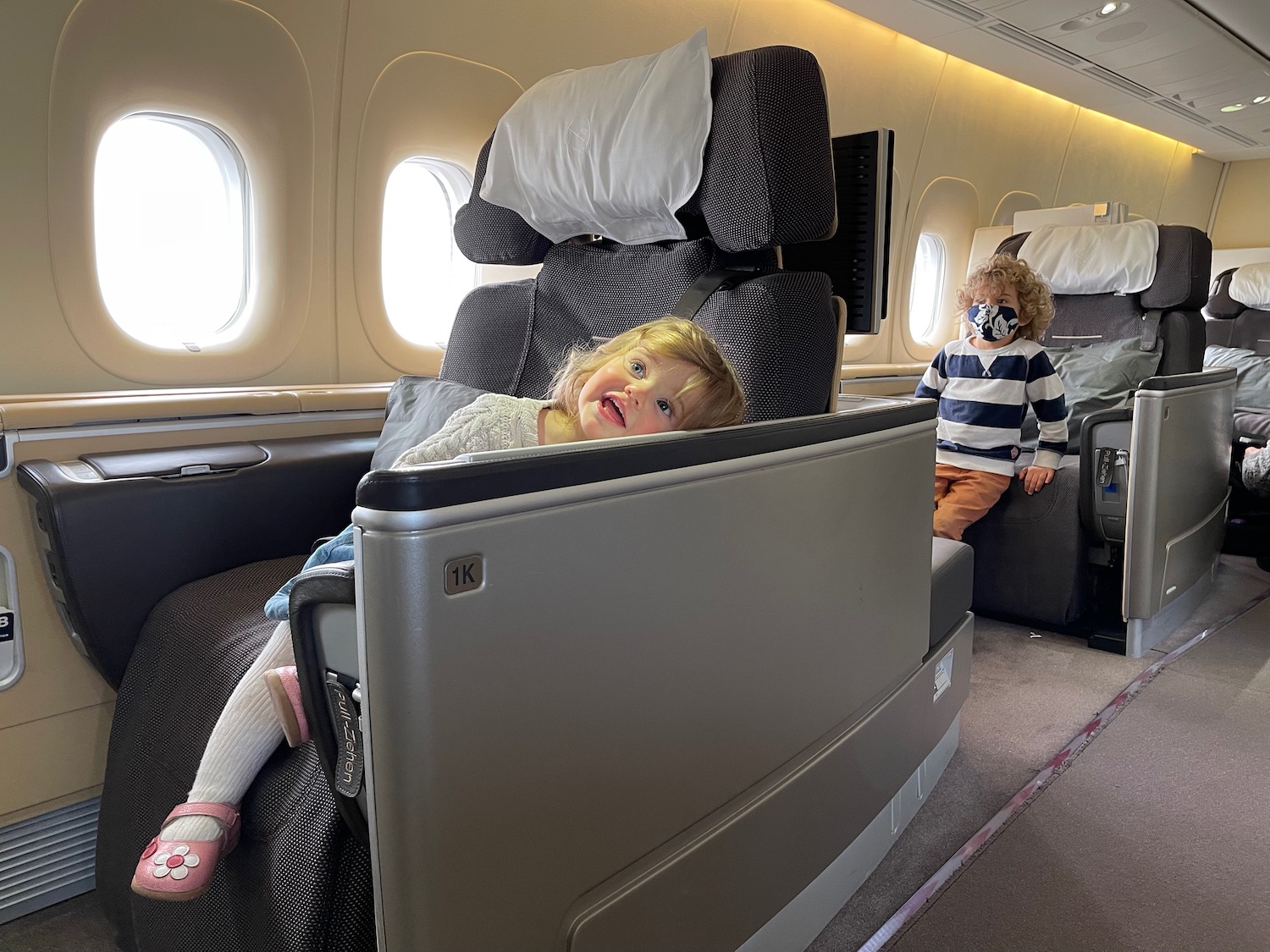 a child sitting in a chair in an airplane