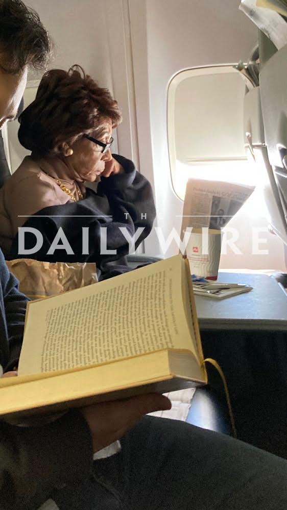 a woman reading a book on an airplane