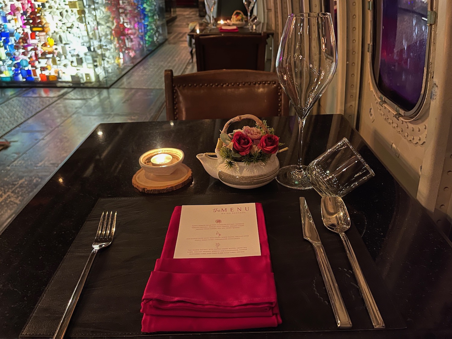 a table with a candle and wine glasses