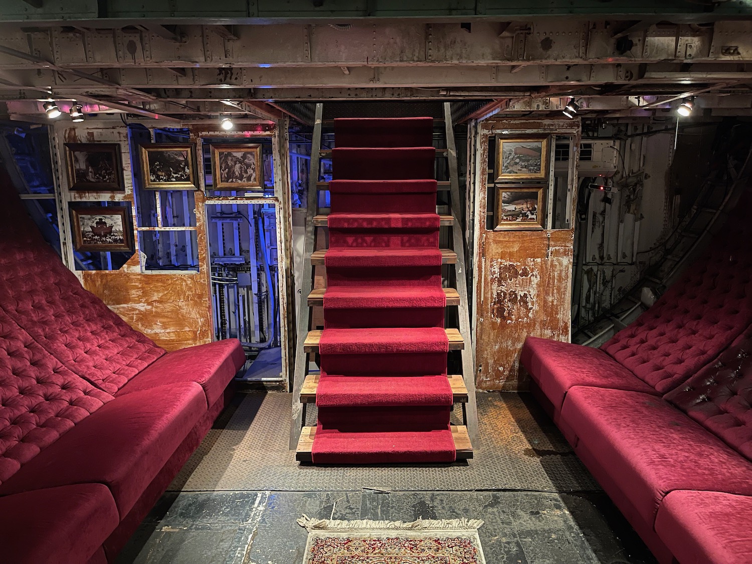 a room with red couches and stairs
