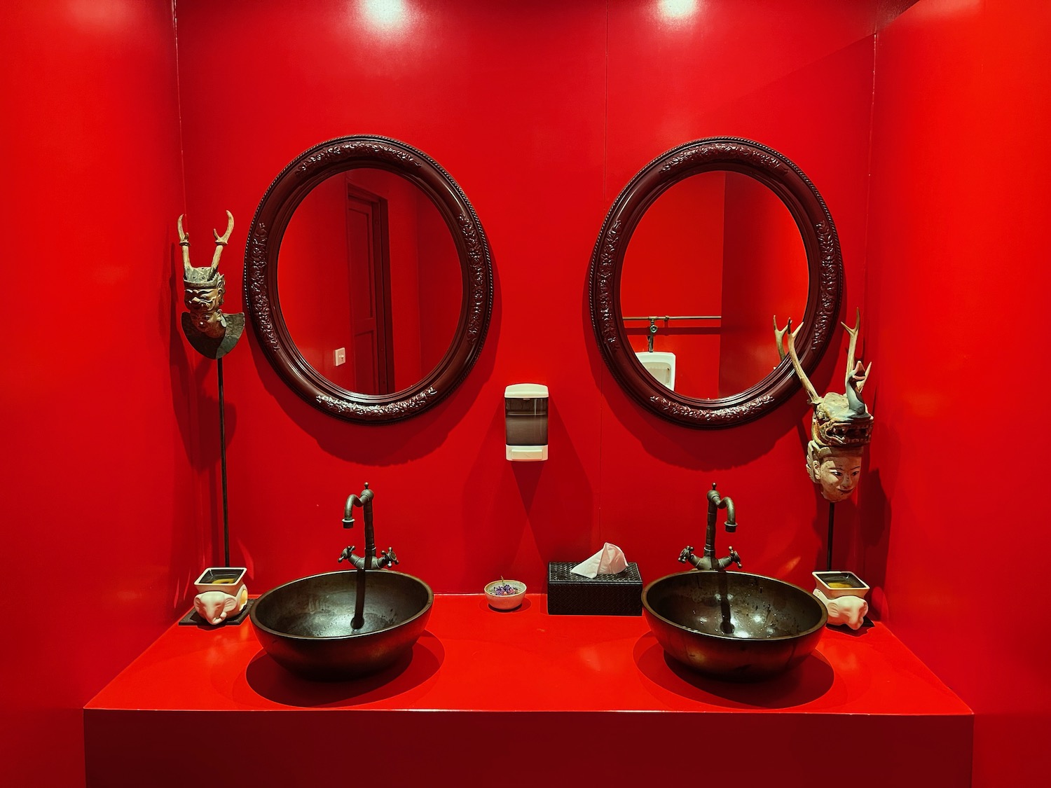 a red bathroom with two sinks and mirrors