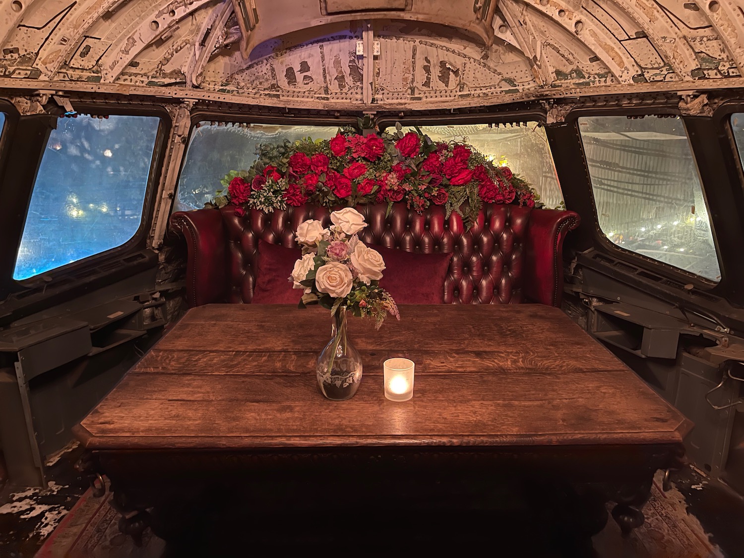 a table with flowers and candles in the cockpit of an airplane